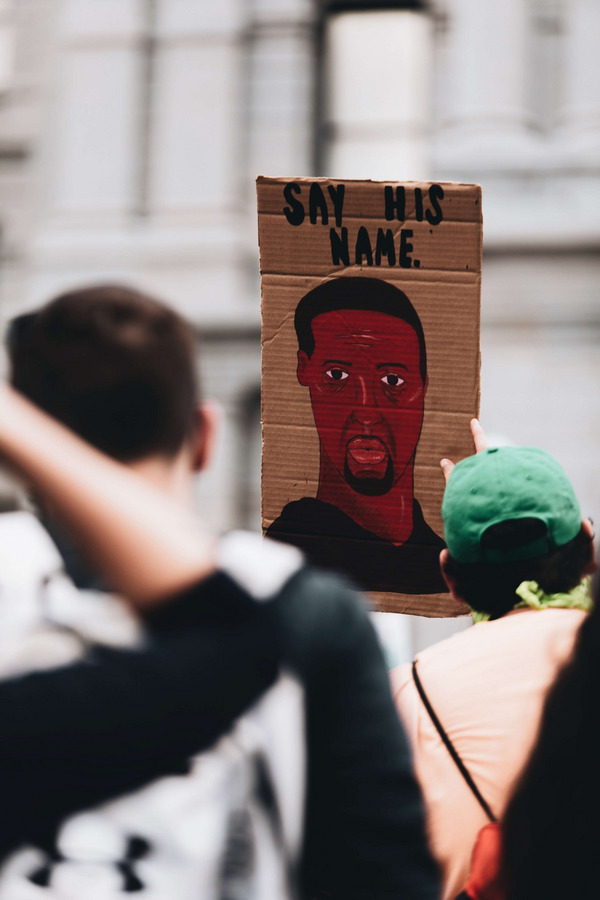 Protest mit Schild, das George Floyd abbildet