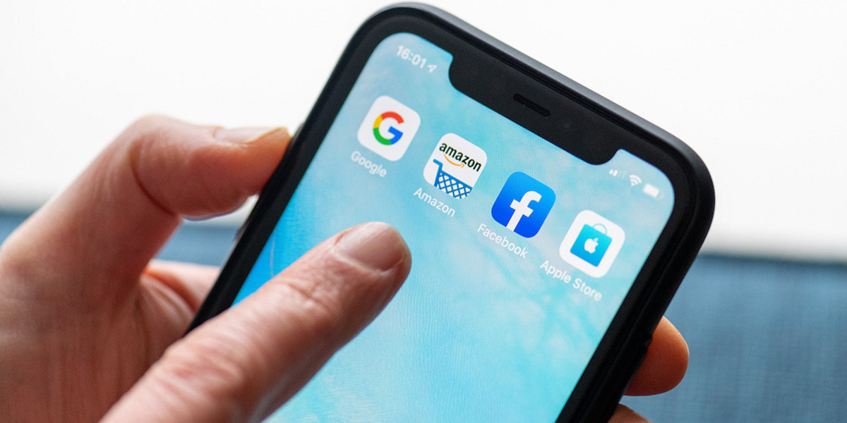 Nahaufnahme von einem Smartphone mit den Icons von Google, Apple, Facebook und Apple Store auf dem Schirm.