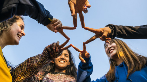 Eine Gruppe von Jugendlichen formt einen Stern mit den Händen