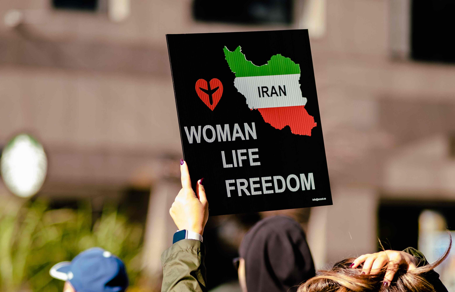 Ein Protestschild mit der Aufschrift "Woman, Life, Freedom"