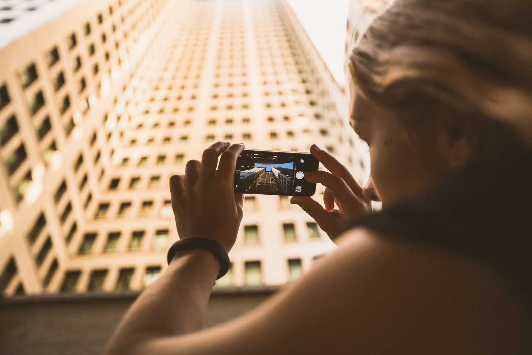 Eine Frau fotografiert ein Hochhaus