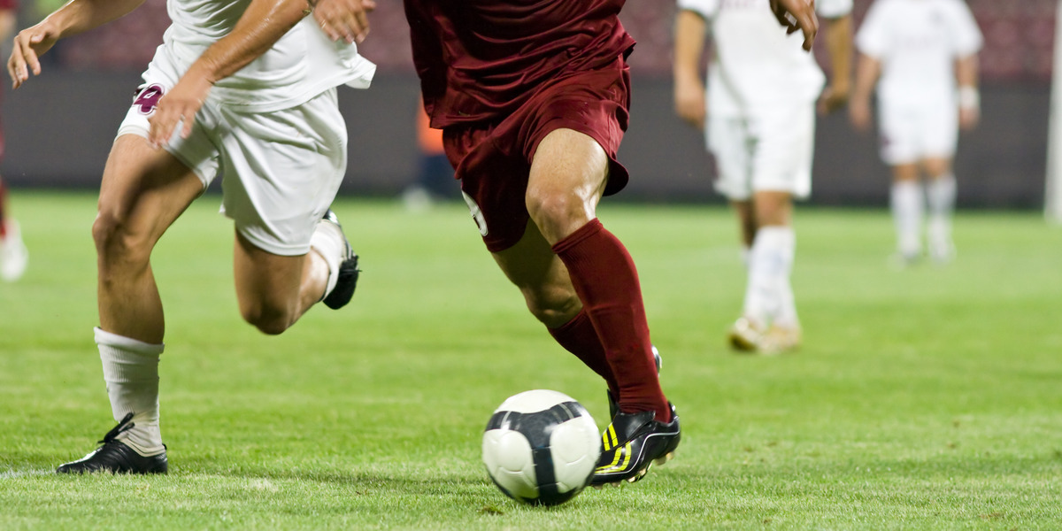 Zwei Fußballer kämpfen auf dem Feld um den Ball