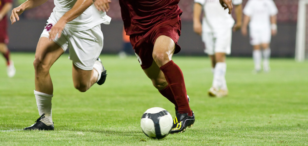 AdobeStock_16658833_KONZERN_ST-CC.jpeg Zwei Fußballspieler kämpfen um den Ball