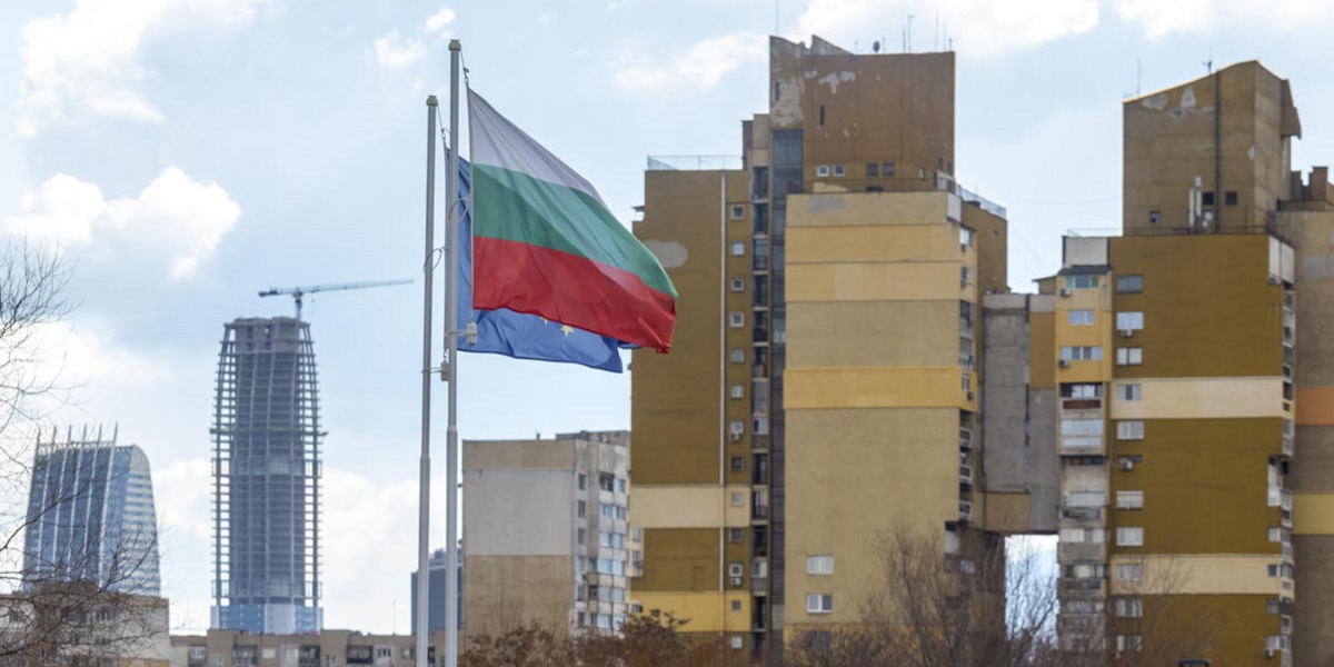 Die bulgarische Flagge und die der EU wehen vor einer Wohnsiedlung in Bulgarien