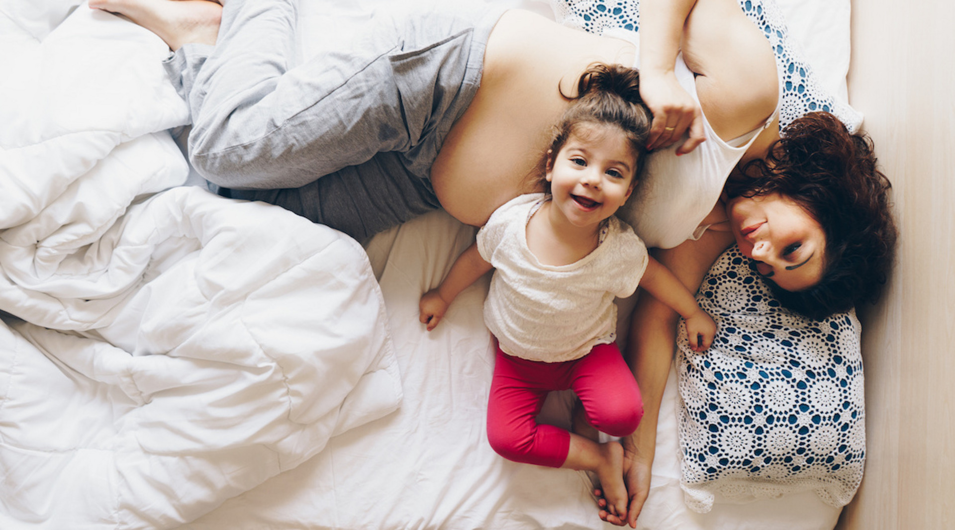 Schwangere Mutter mit ihrem Kind im Bett