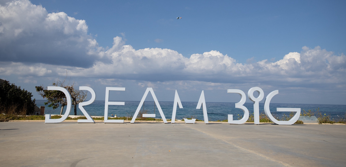 Der Schriftzug "Dream Big" in großen Lettern an der Meeresküste in Israel
