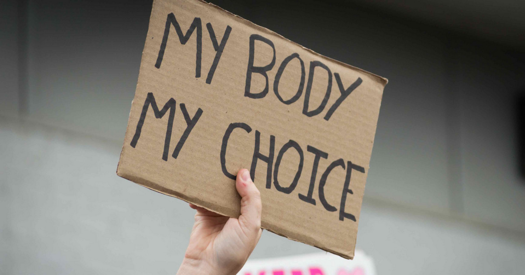 Eine Hand hält einen Schild mit dem Text "MY BODY MY CHOICE".