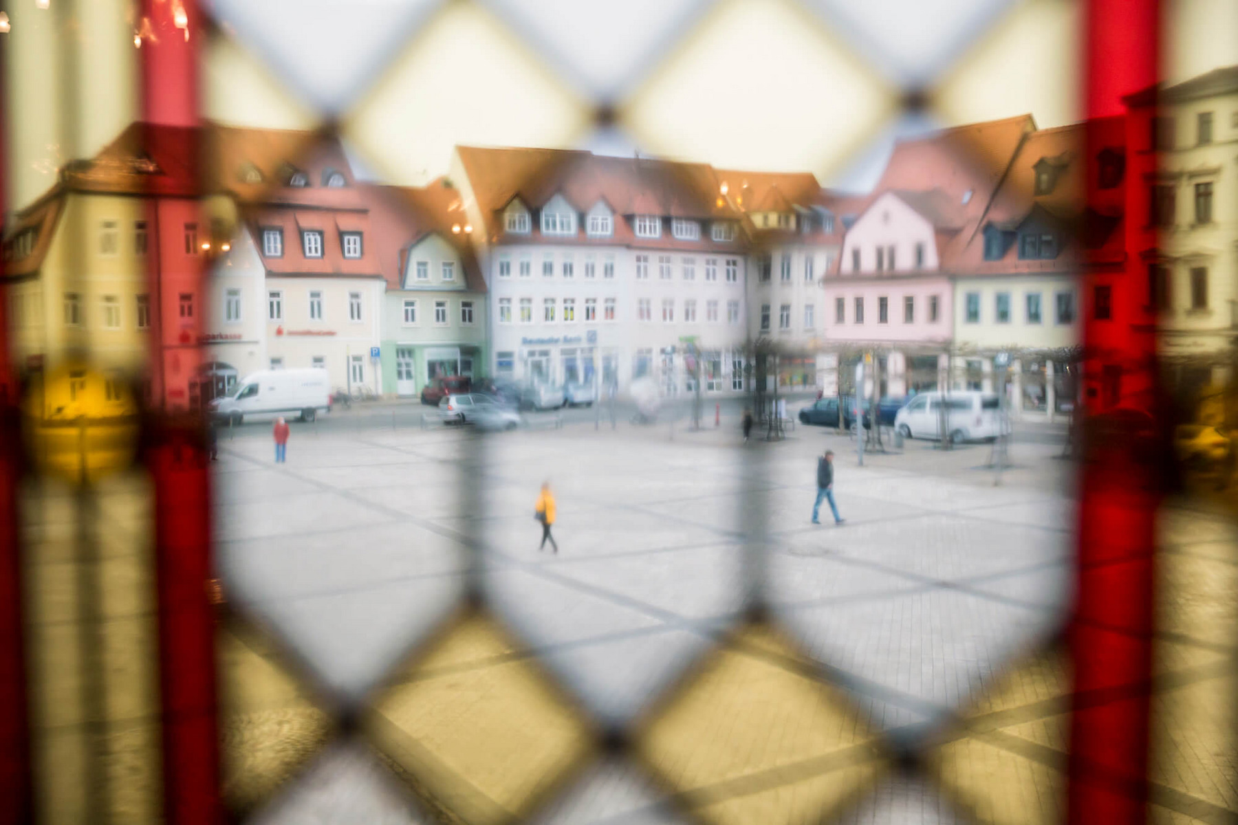 Ein Blick durch farbige Butzenfenster auf den Rathausplatz im sächsischen Borna