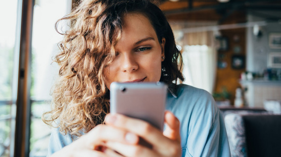 Eine Frau scrollt durch Social-Media-Feeds.