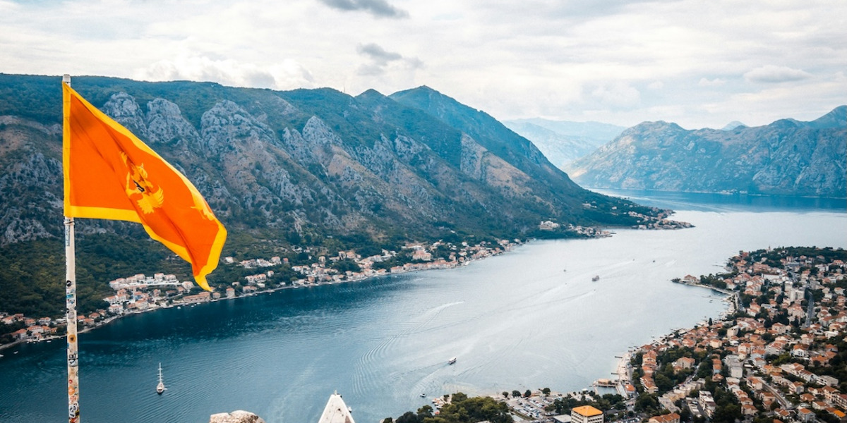 Blick von der Festung in der Stadt Kotor auf die Bucht, mit montenegrinischer Flagge