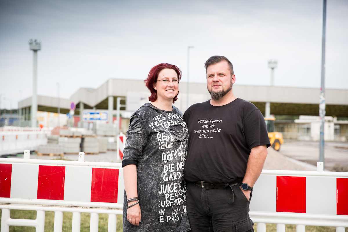 Kathrin und Yves Graf vor einem Zaun an der Gedenkstätte Marienborn.