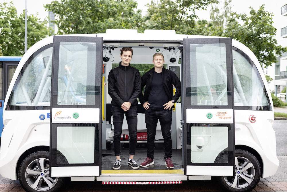 Zwei studentische Begleiter im elektrischen Robobus, der von KI gesteuert wird.