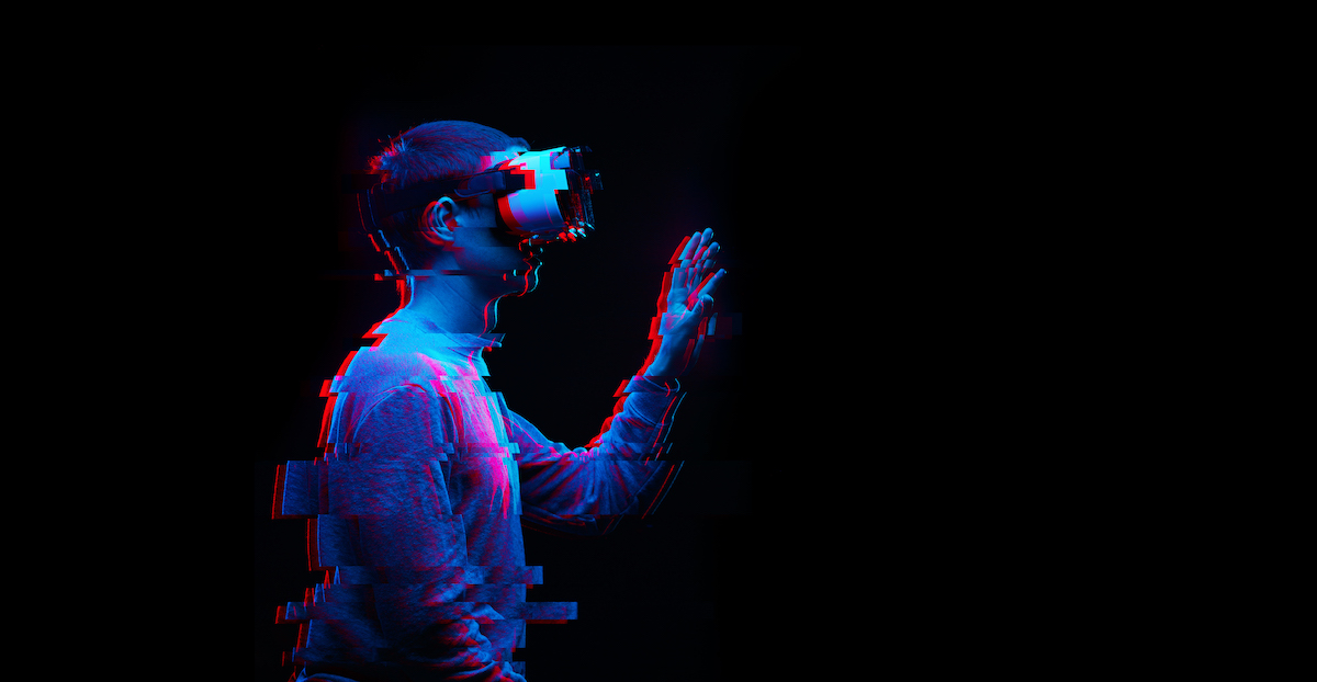 Eine Person trägt eine Virtual-Reality-Brille und greift mit der Hand in der Luft.