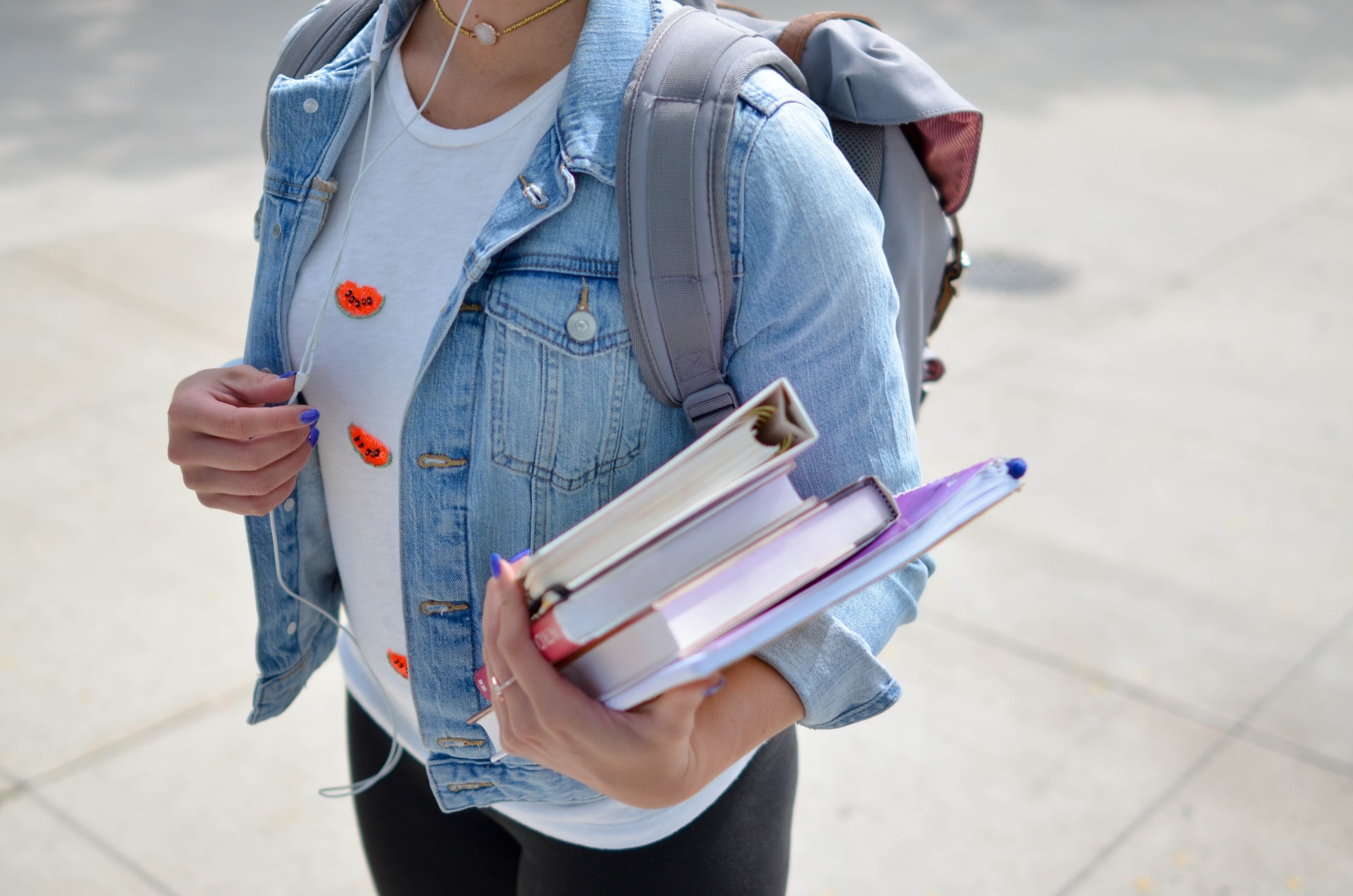 Eine junge Frau hält Bücher in den Händen.