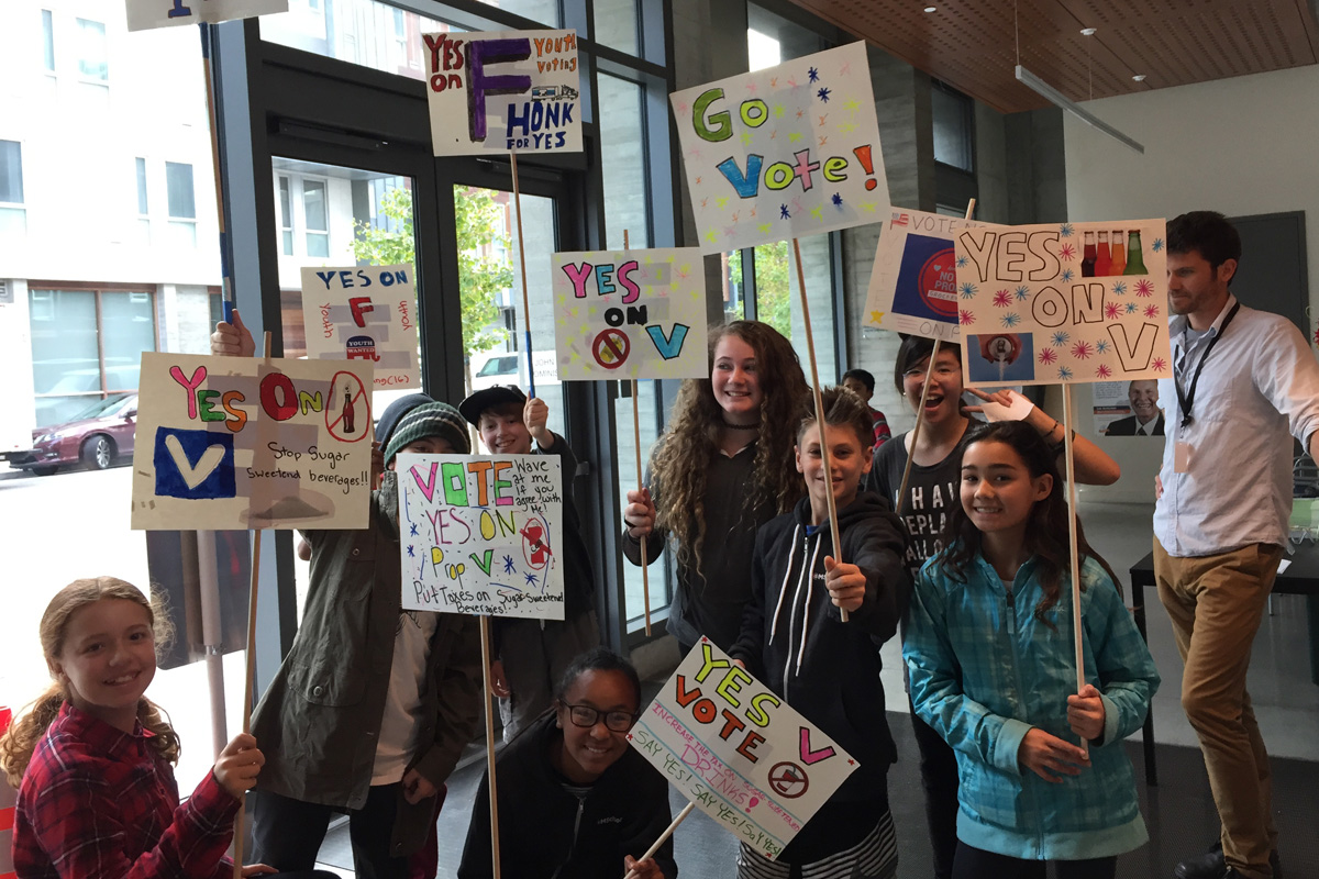 Foto von Schülern mit gebastelten Schildern zum Thema Volksentscheid